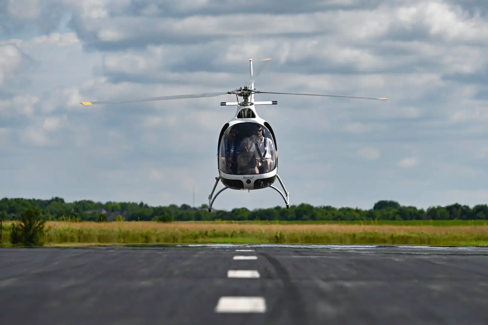Front low angle view of a helicopter taking off in a runway