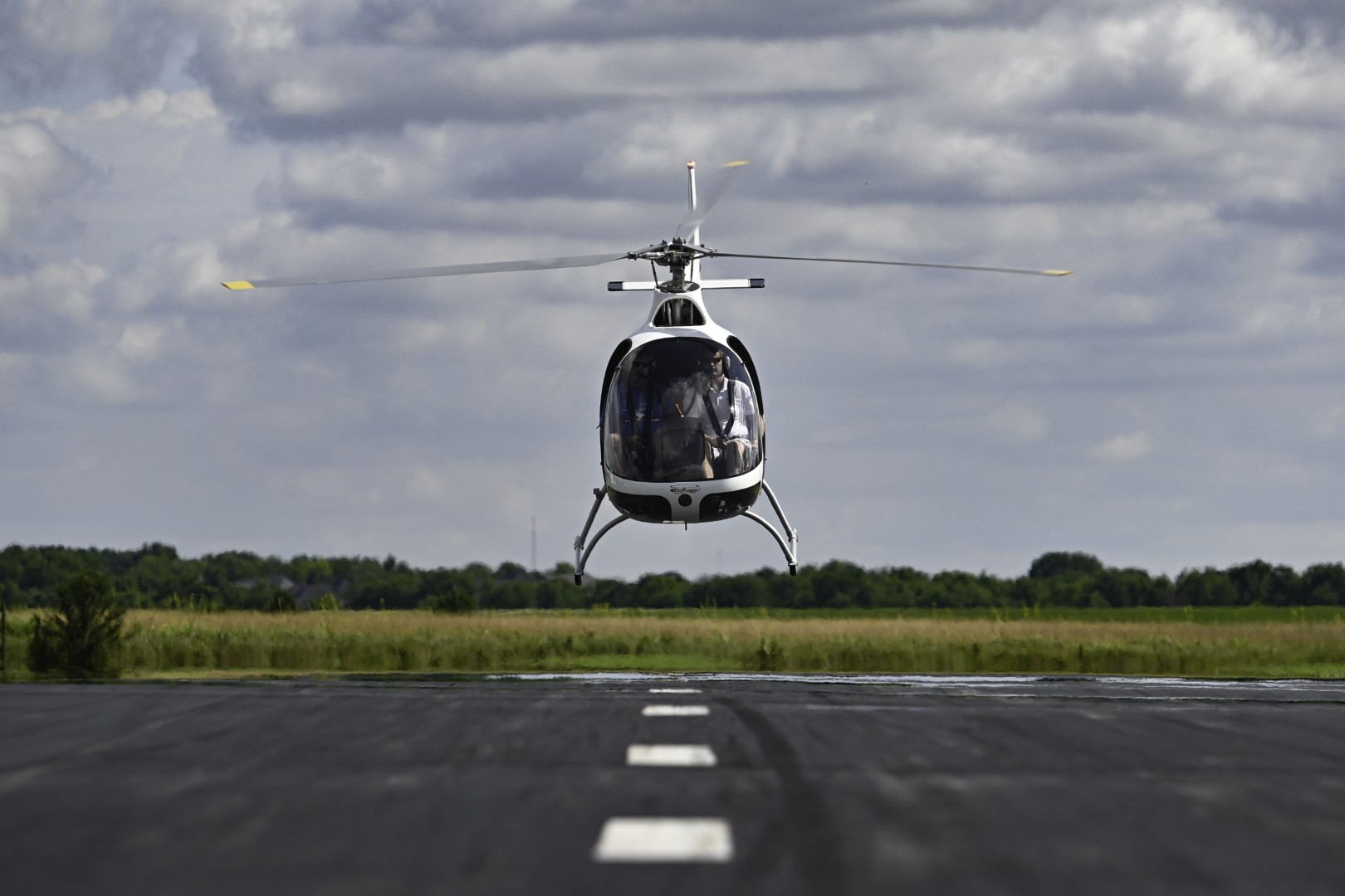 Front low angle view of a helicopter taking off in a runway